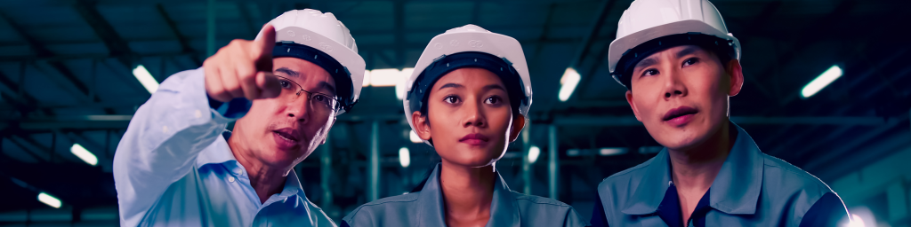 A team of engineers at a factory pointing