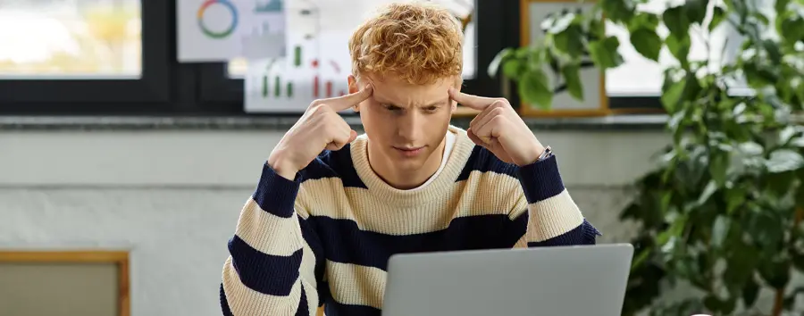 Confused man looking at laptop