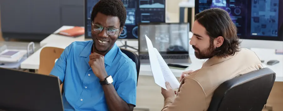 two cyber security professionals happy looking at data