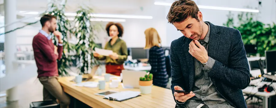 man using phone in modern office space